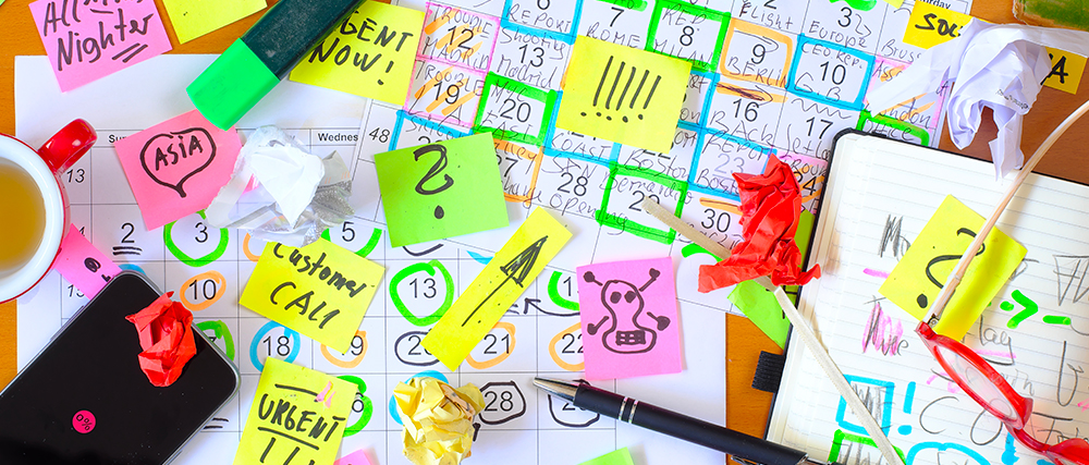 Bureau avec plein de post-it, cahier et annotations
