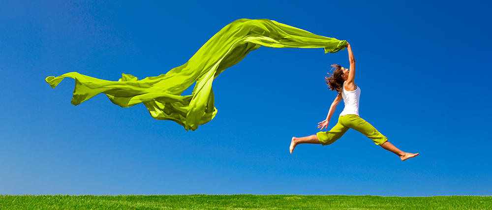 femme-energie-joie Femme énergique qui saute en l'air un foulard vert dans ses mains